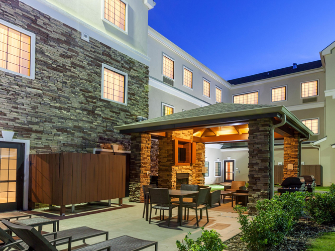 Outdoor hotel courtyard with stone fireplace and seating